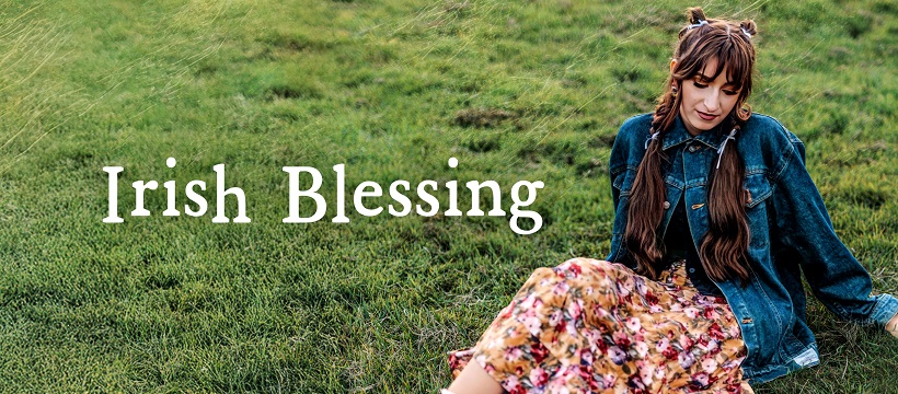 Felicity Kircher sitting on a lush grassy hill.